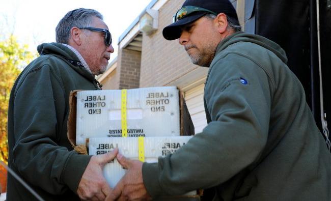 Garfield County staff hand two boxes of ballots over to the post office in Glenwood Springs.